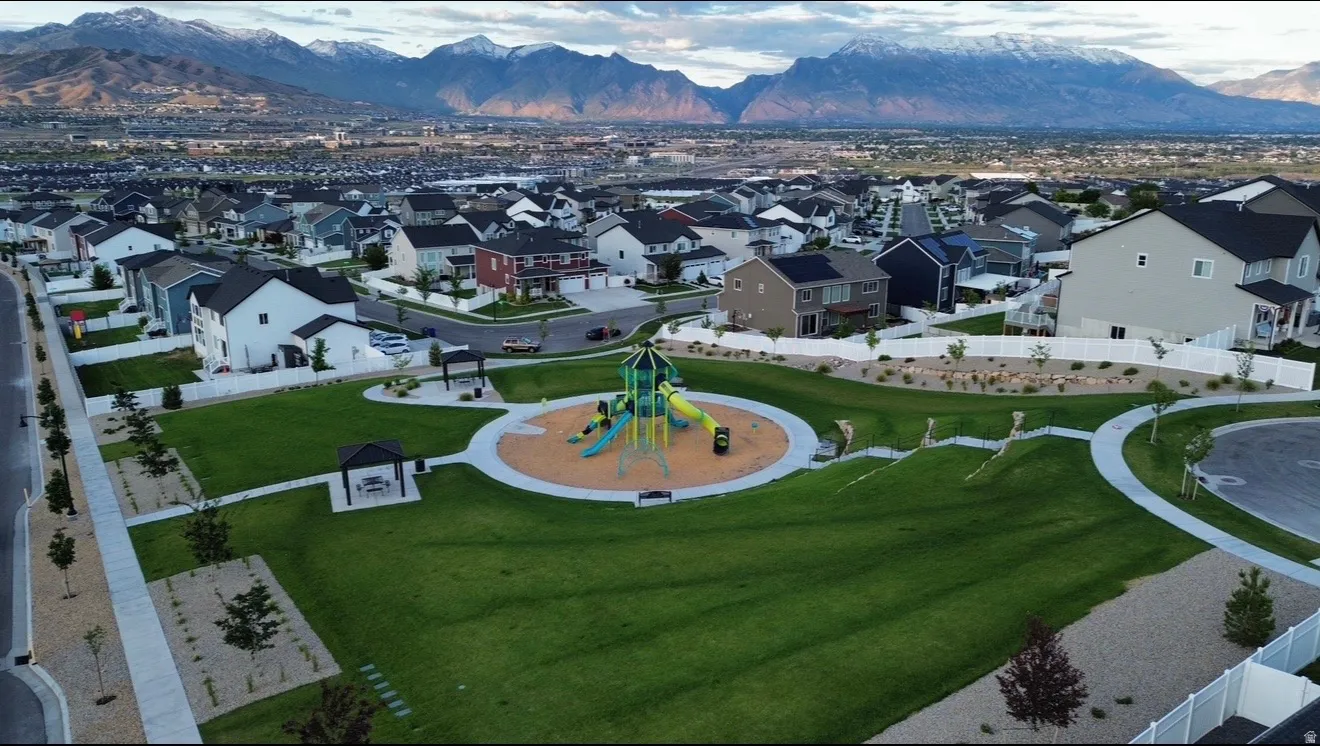 Community park featuring a central playground with multiple slides and climbing structures