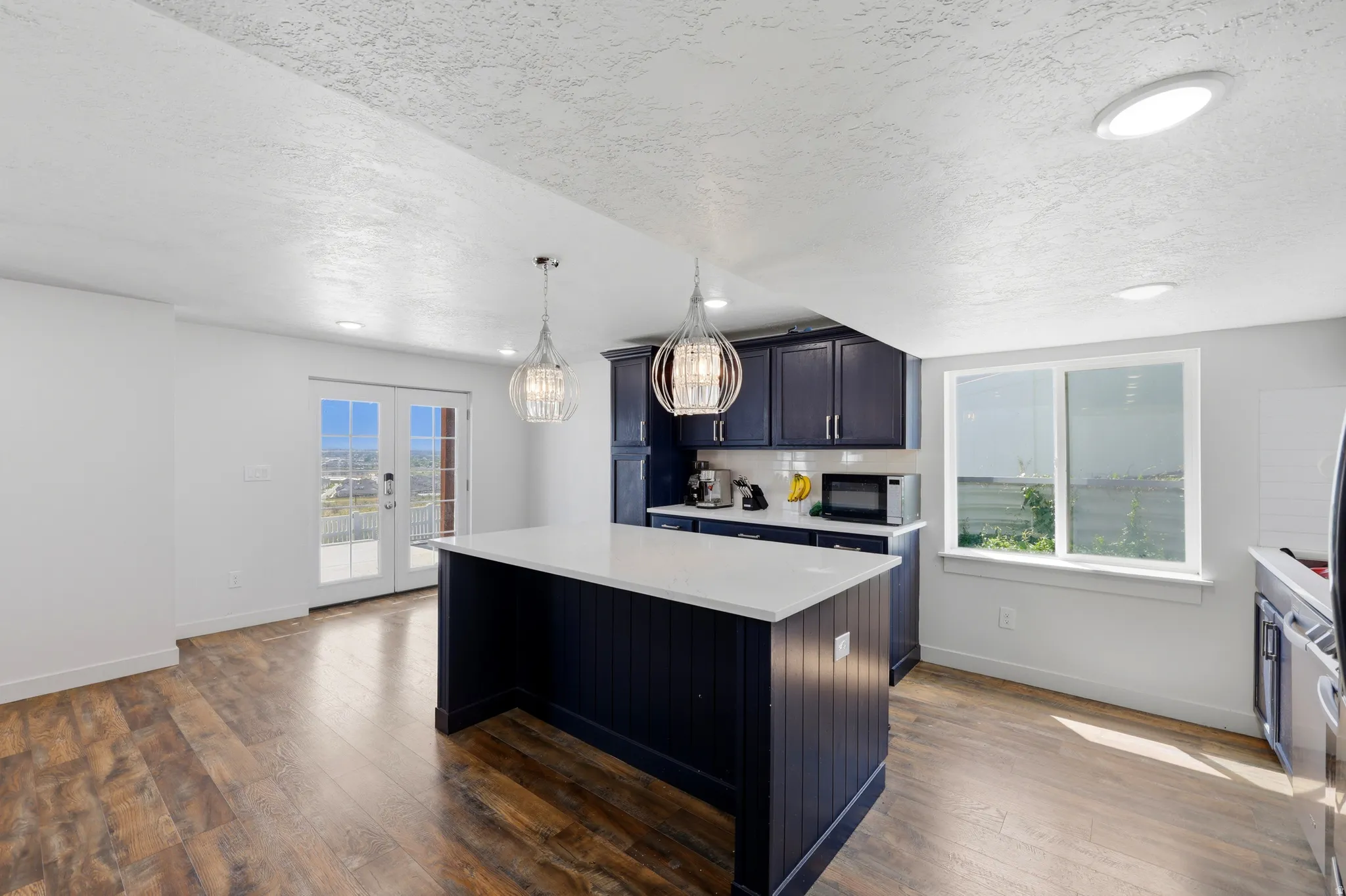 Kitchen island with a white countertop and dark blue cabinetry