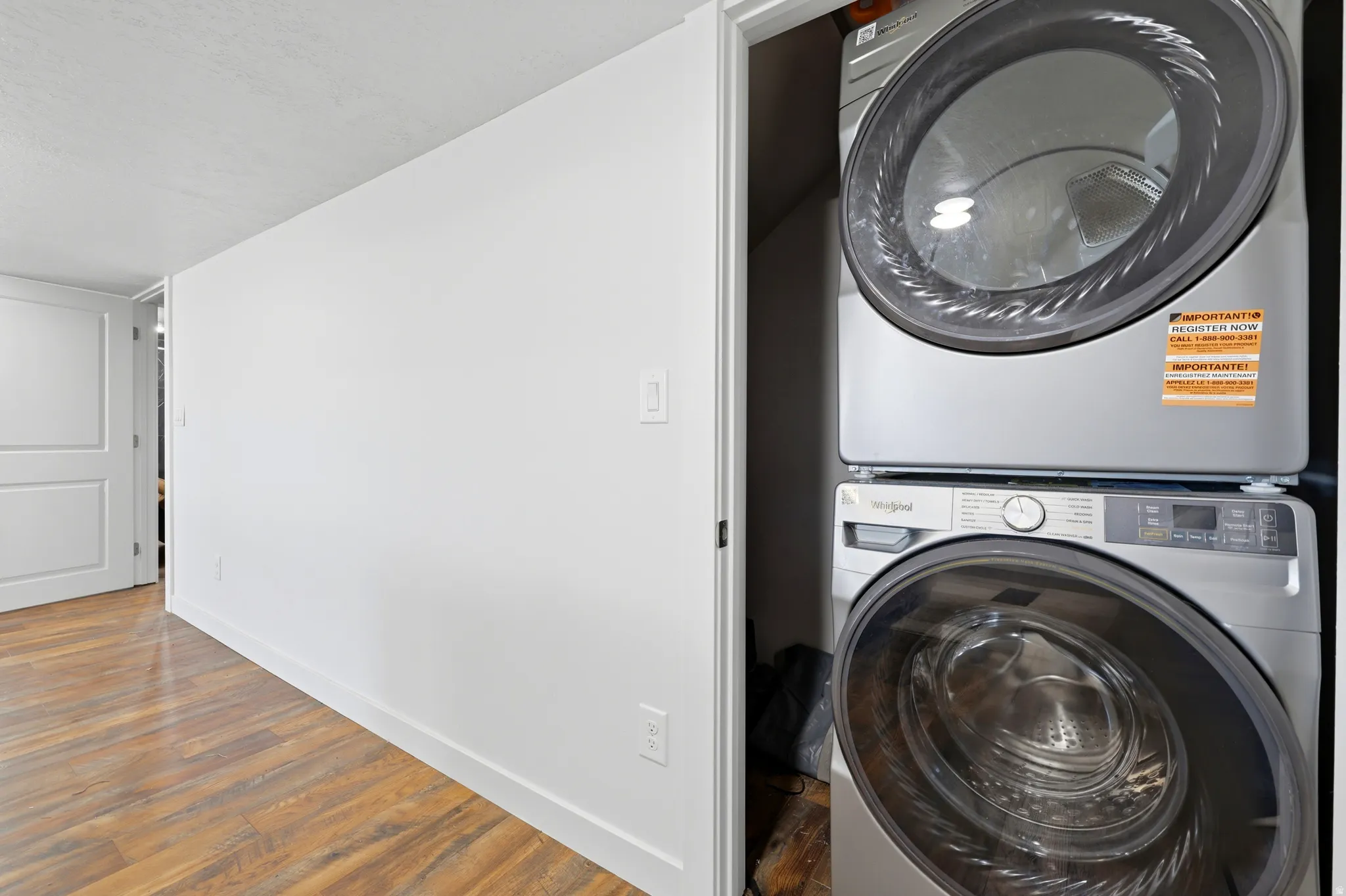 Dedicated laundry closet featuring a stacked washer and dryer unit