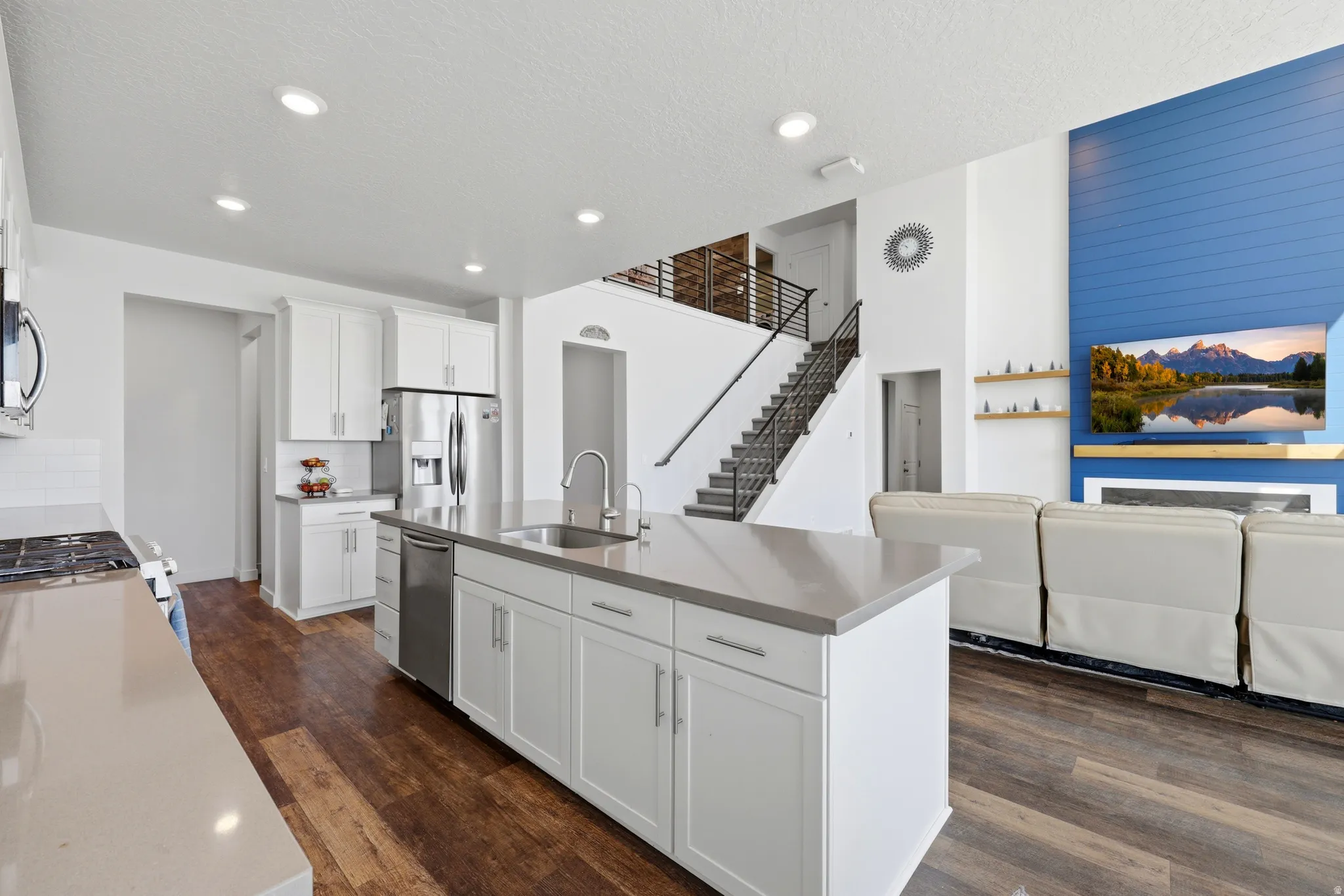Modern kitchen island with integrated sink and dishwasher, complemented by stainless steel appliances