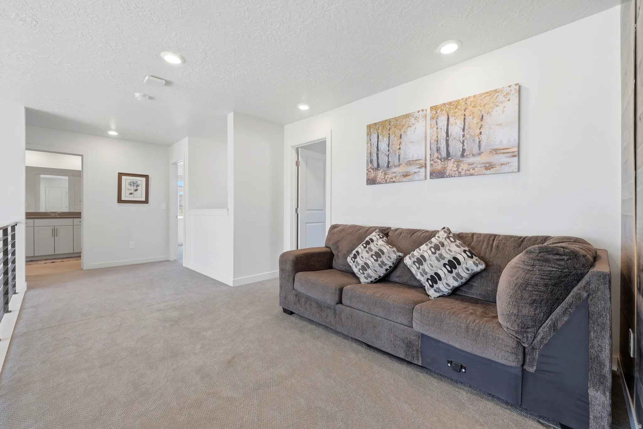Carpeted loft space featuring recessed lighting and a contemporary metal railing