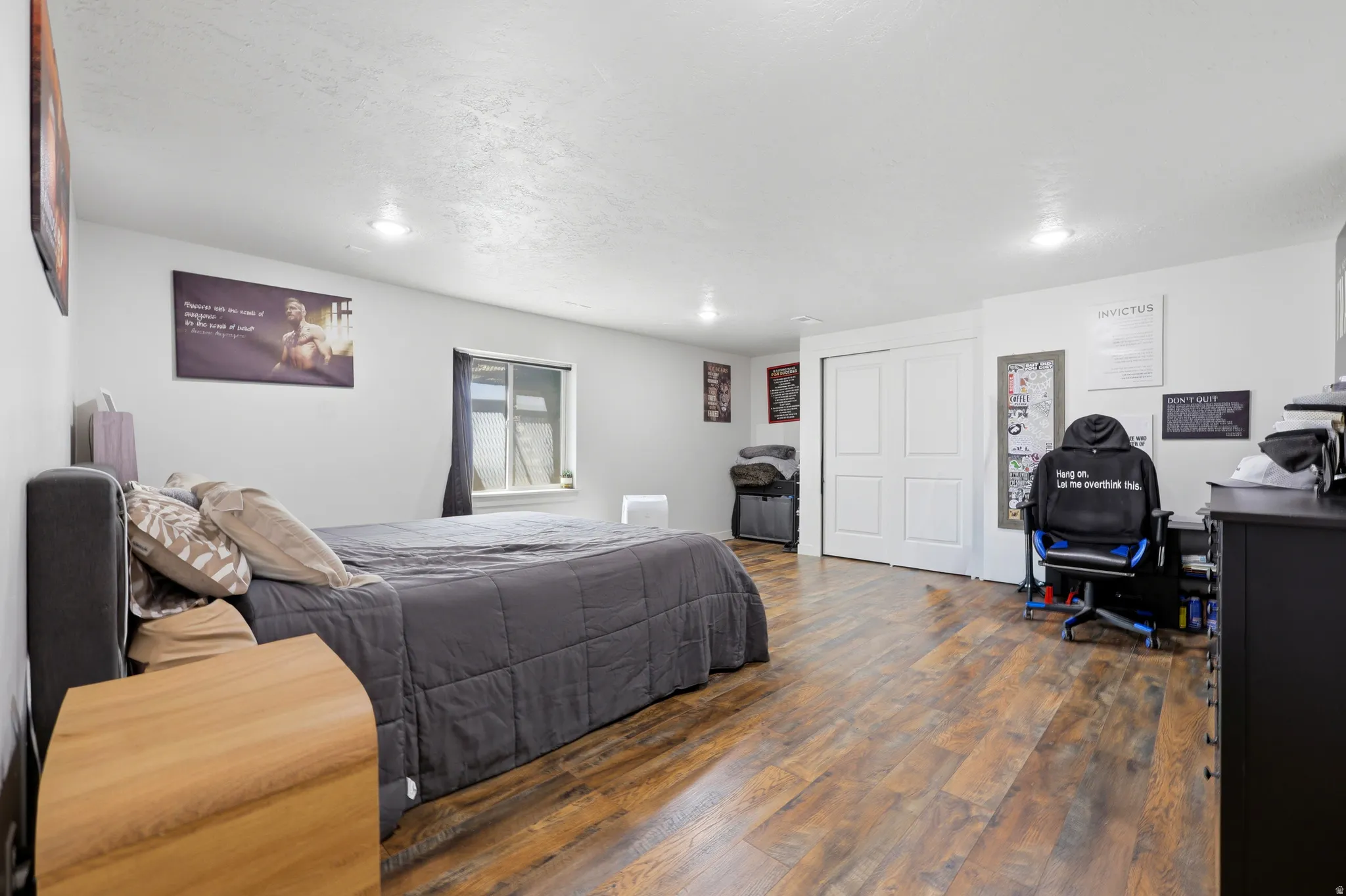 Spacious room with wood-finish flooring, white walls, and recessed lighting