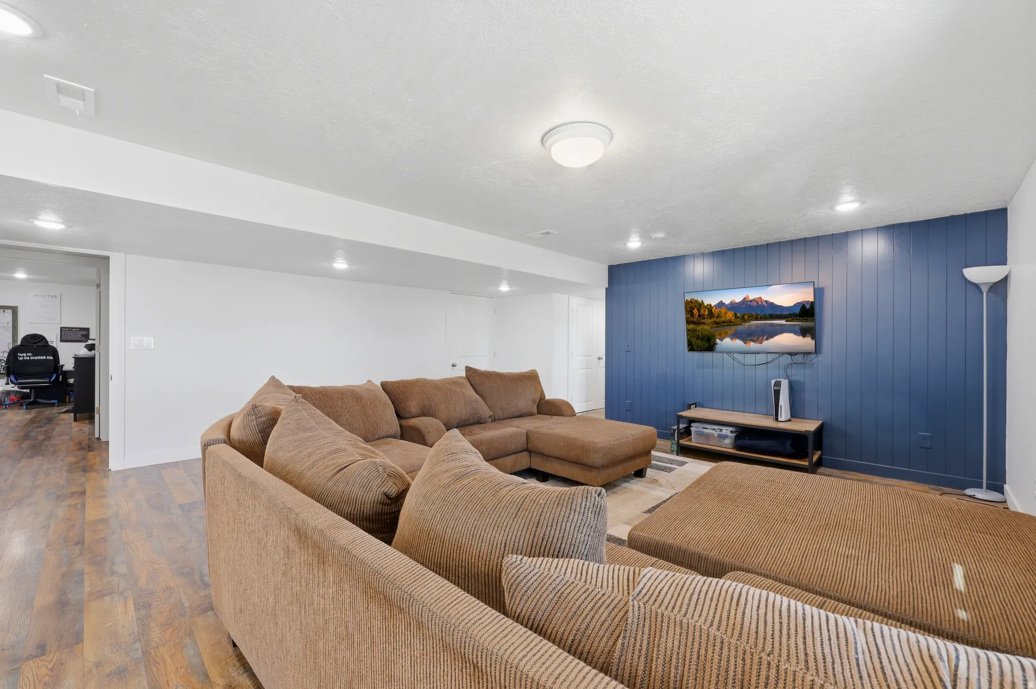 Spacious living area featuring wood-finish flooring and recessed lighting