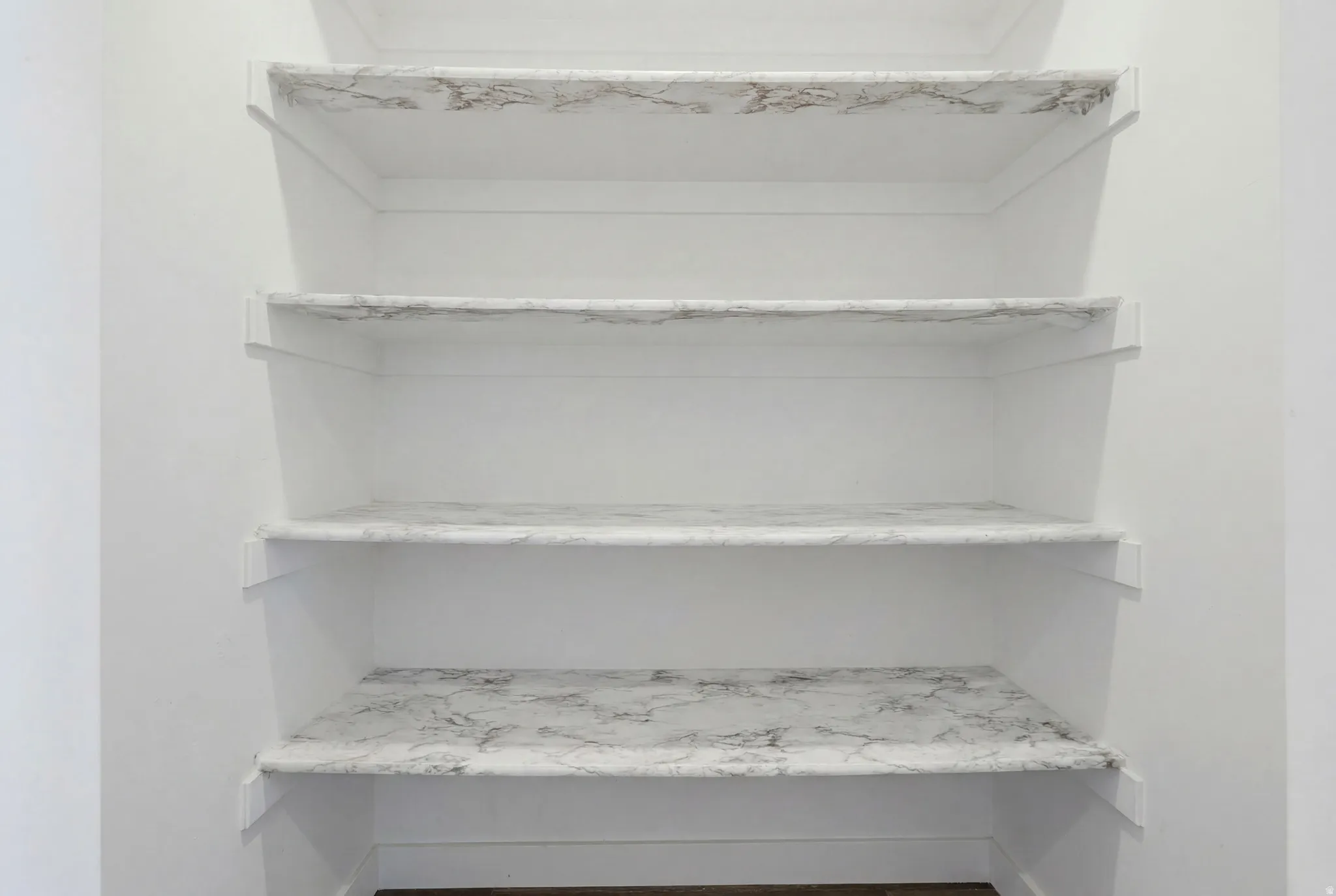 Built-in shelving unit featuring four levels with a light-toned, veined surface finish
