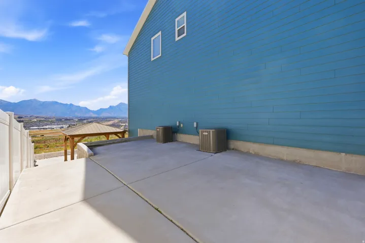 Expansive concrete patio area with a white privacy fence