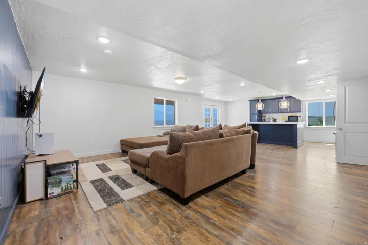 Open-concept living area featuring wood-finish flooring, recessed lighting, and a kitchen with dark cabinetry