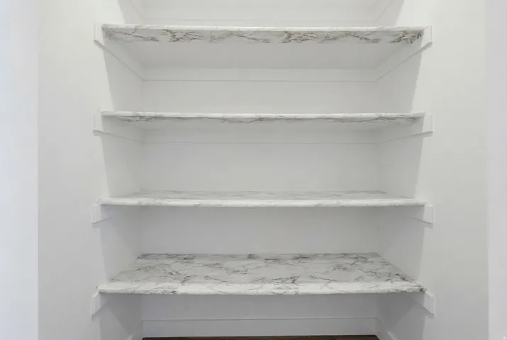 Built-in shelving unit featuring four levels with a light-toned, veined surface finish
