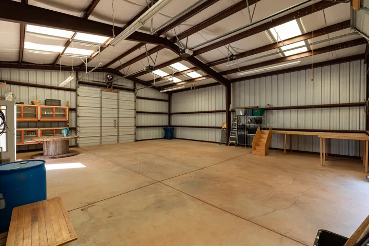 Spacious workshop with concrete flooring and exposed metal beam construction
