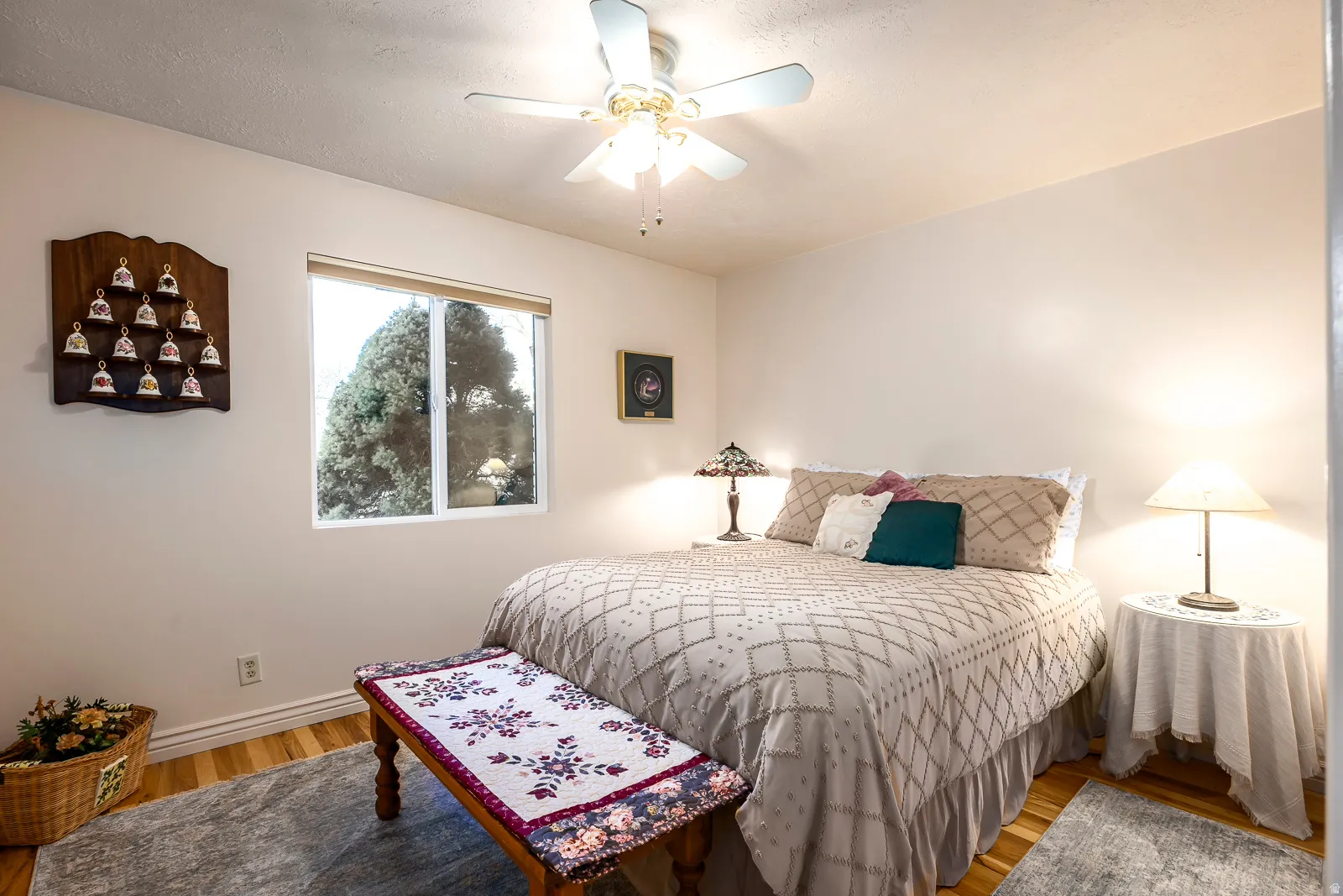 Bedroom featuring wood-finish flooring, a ceiling fan with integrated lighting, and a double-paned window