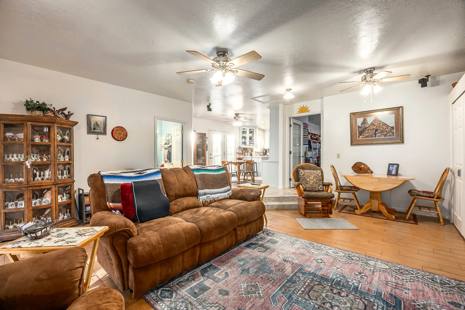 Open-concept living area featuring wood-finish flooring, recessed lighting, and multiple ceiling fans