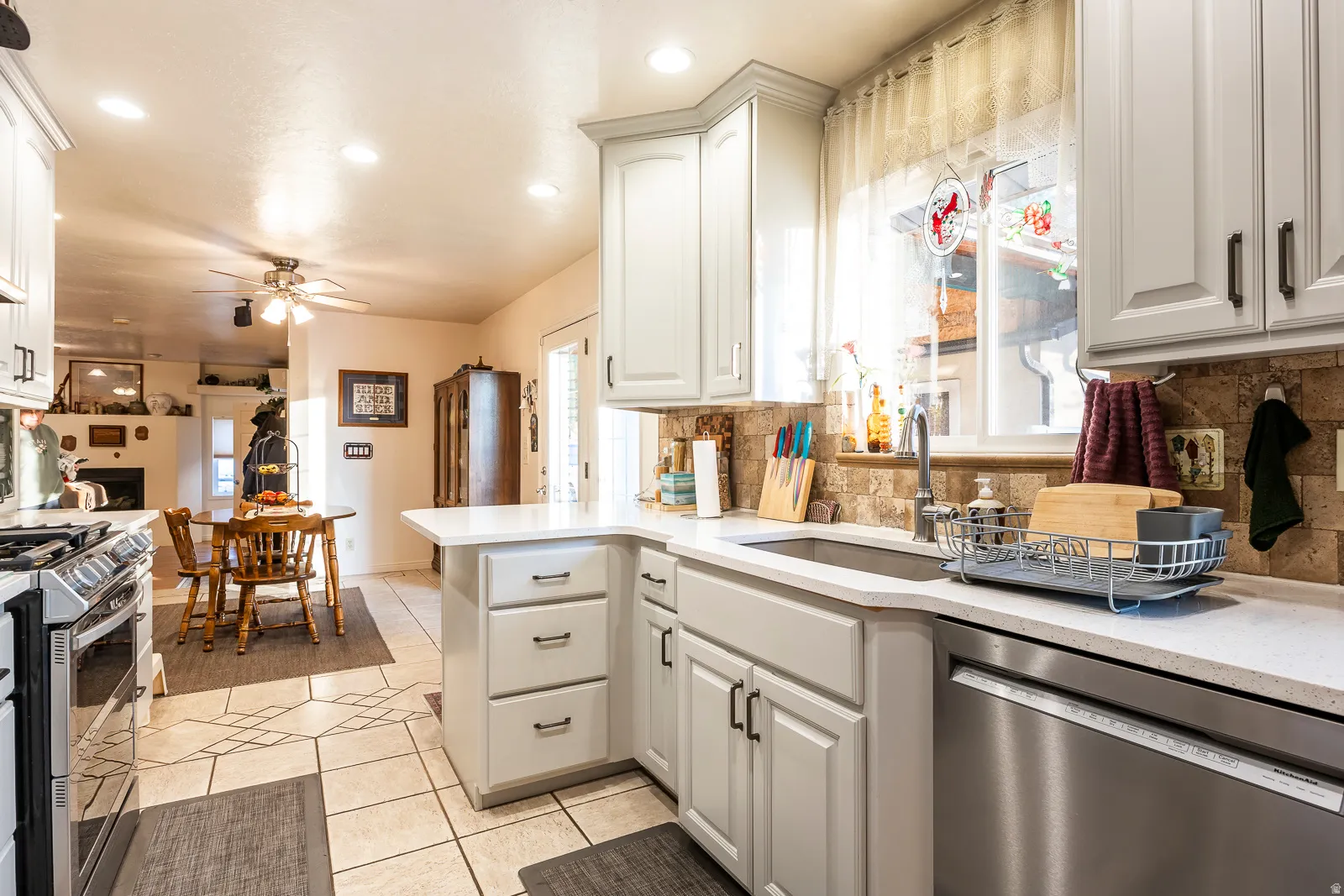 Kitchen featuring light cabinetry with dark hardware, a stainless steel sink, and stainless steel dishwasher
