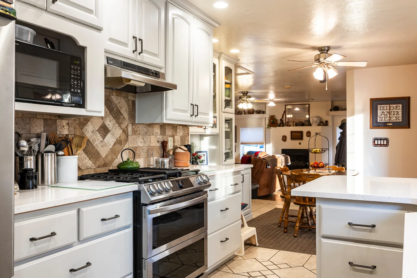 Kitchen featuring white cabinetry, a built-in microwave, and a stainless steel gas range with a double oven
