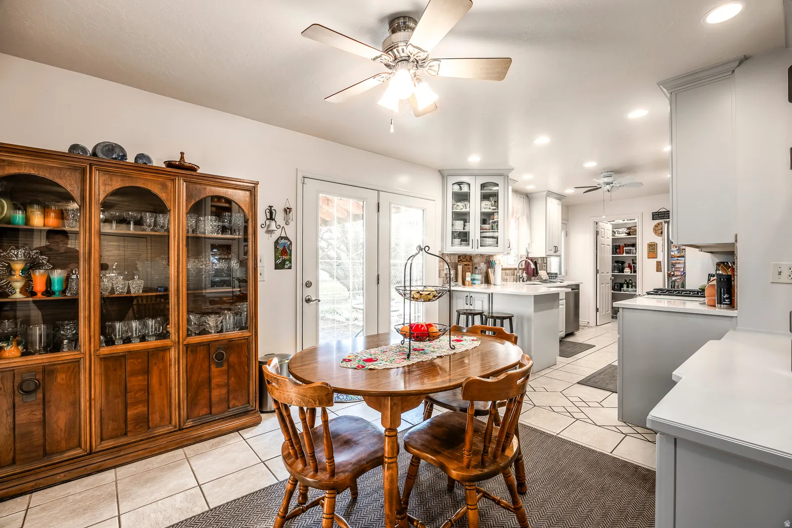 Spacious kitchen and dining area featuring light-toned cabinetry, light-colored countertops, recessed lighting, and tile flooring
