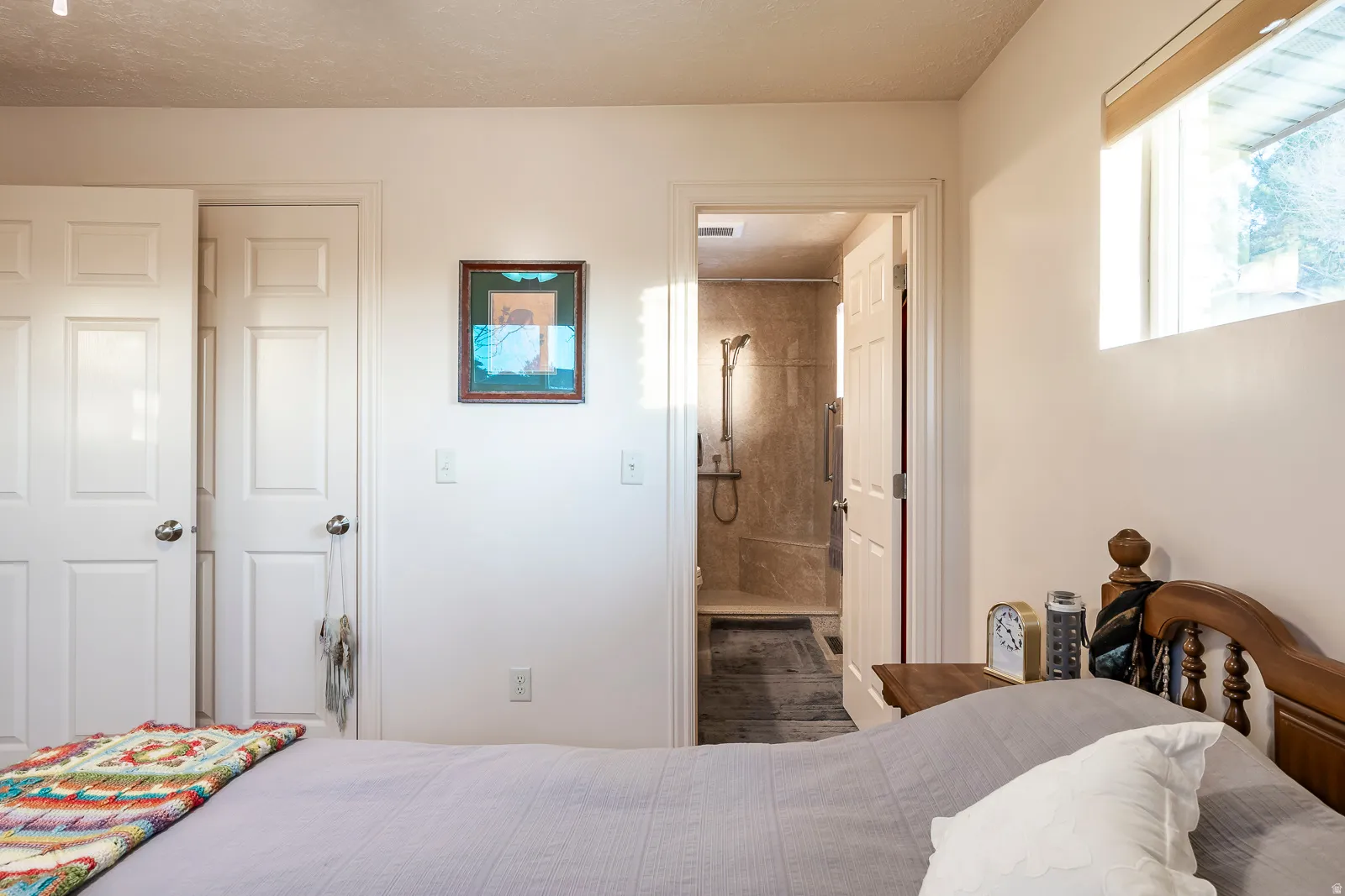 Interior bedroom featuring a light wall color, a window with a valance, and white paneled doors