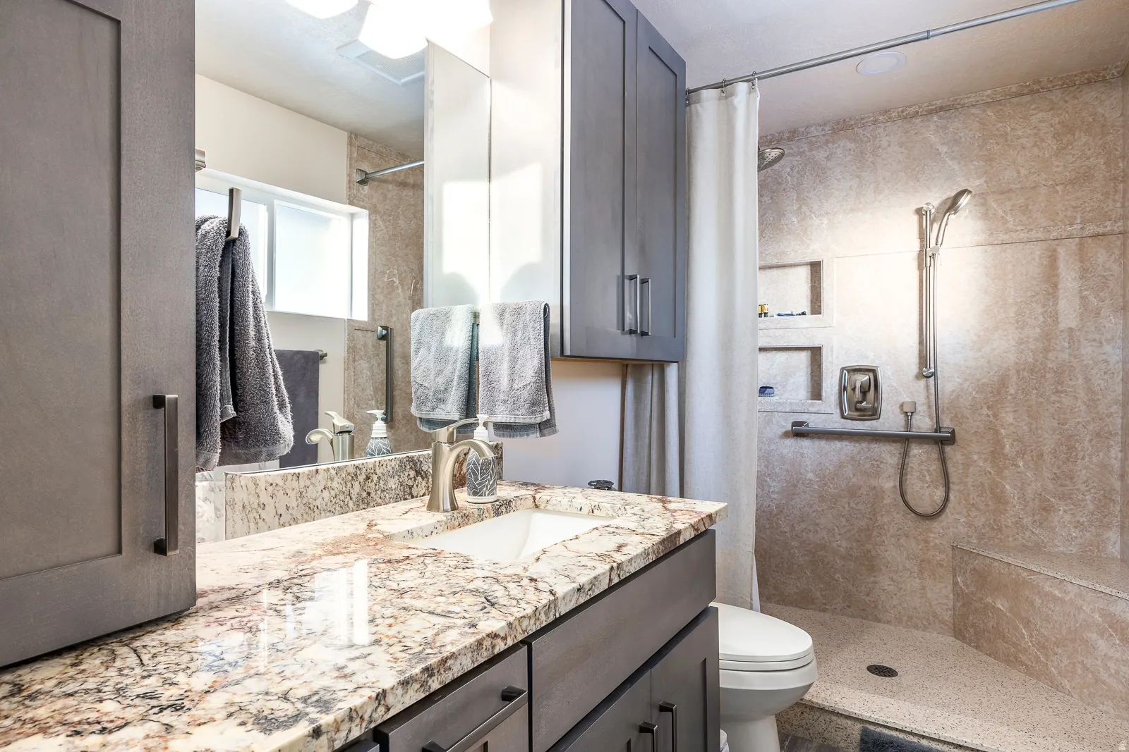 Bathroom featuring a contemporary vanity with a stone countertop and an undermount sink