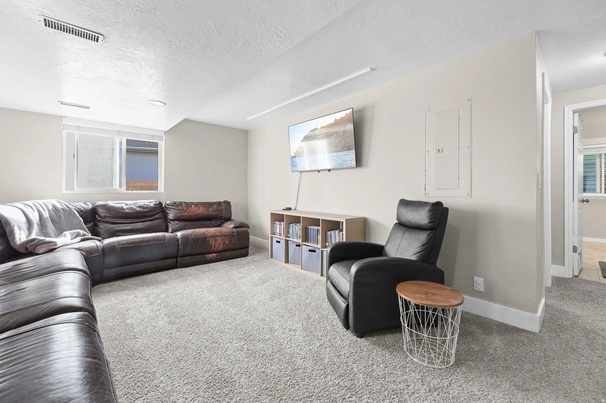 Spacious room featuring light-colored walls, recessed lighting, and soft grey carpeting throughout