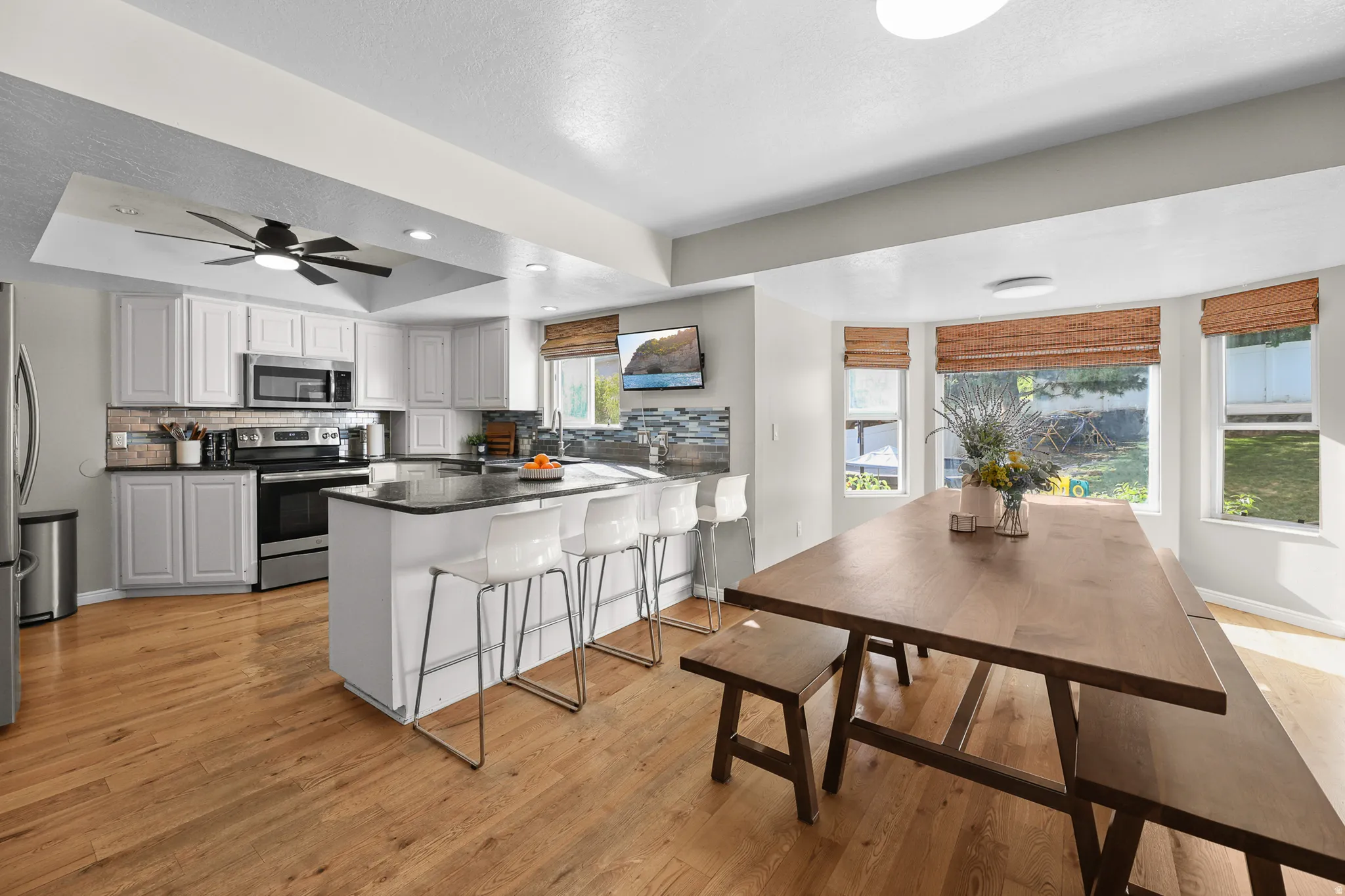 Open-concept kitchen and dining area featuring light wood-finish flooring