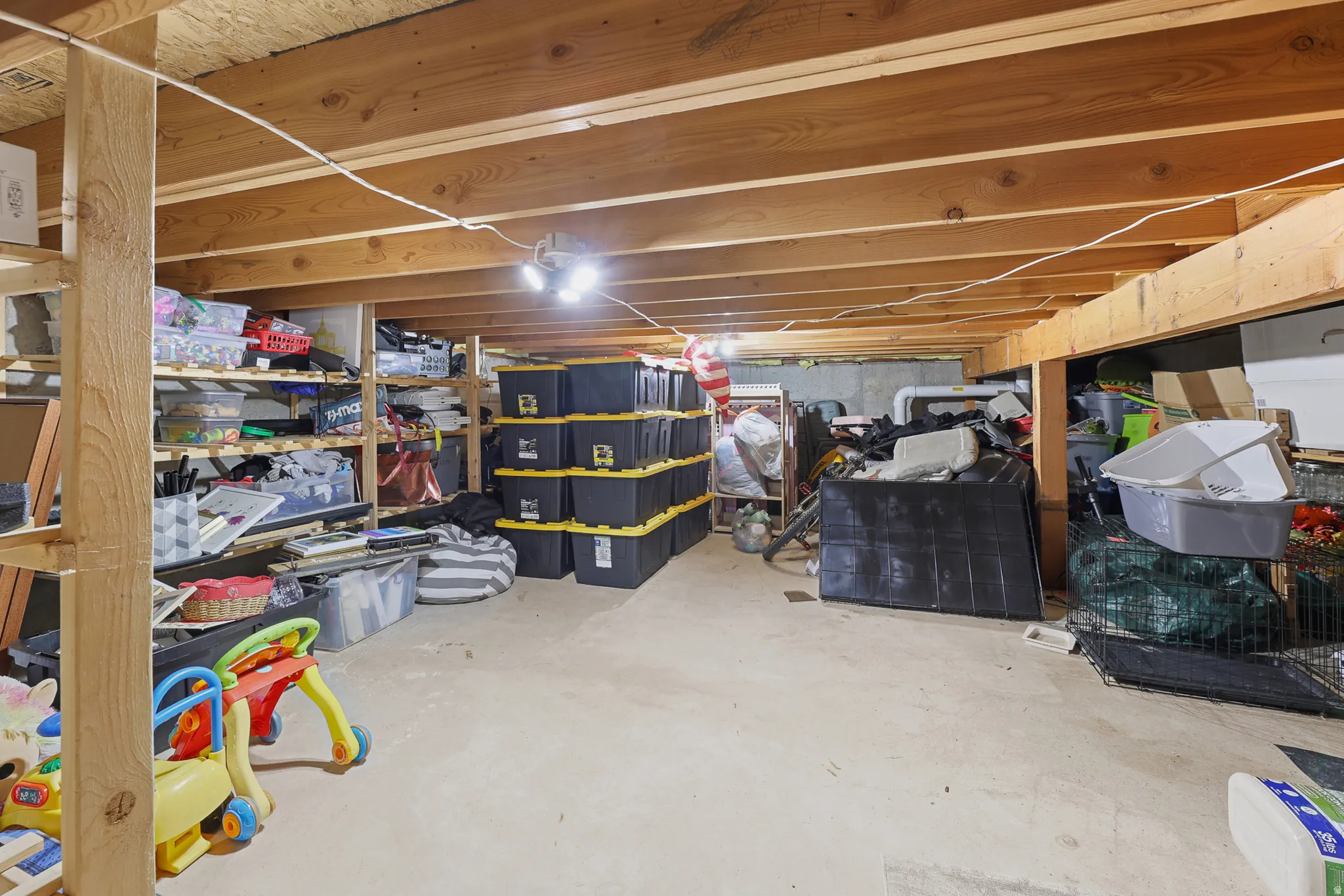 Unfinished basement space featuring exposed wood joists and a concrete floor
