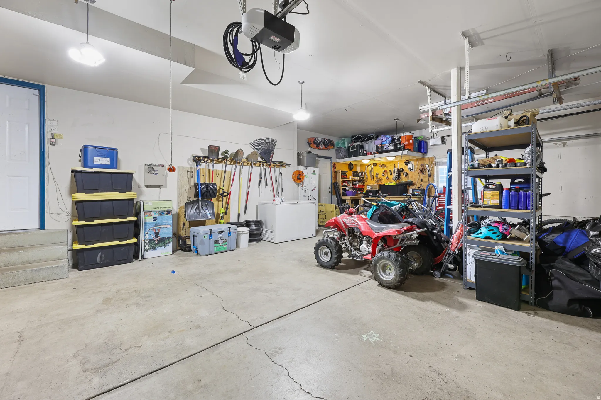 Spacious garage featuring a concrete floor, white walls, and overhead lighting
