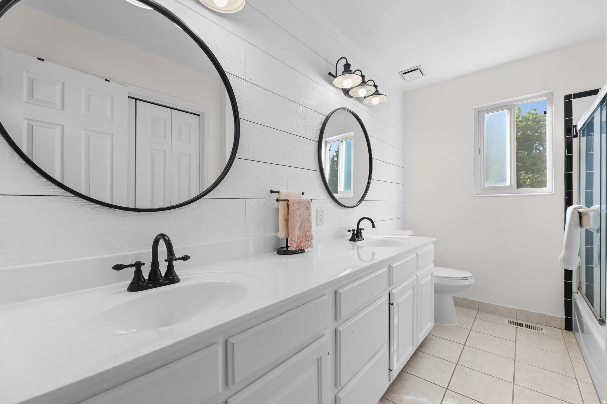 Dual vanity with white cabinetry and integrated sinks, complemented by matte black fixtures