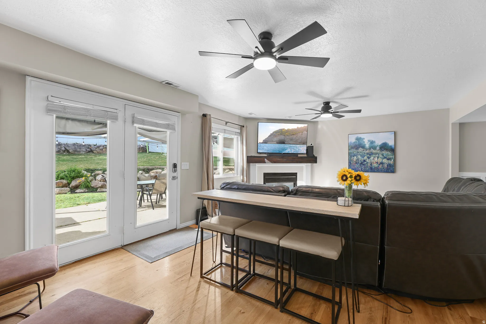 Living area featuring light wood-finish flooring, recessed lighting, and dual ceiling fans