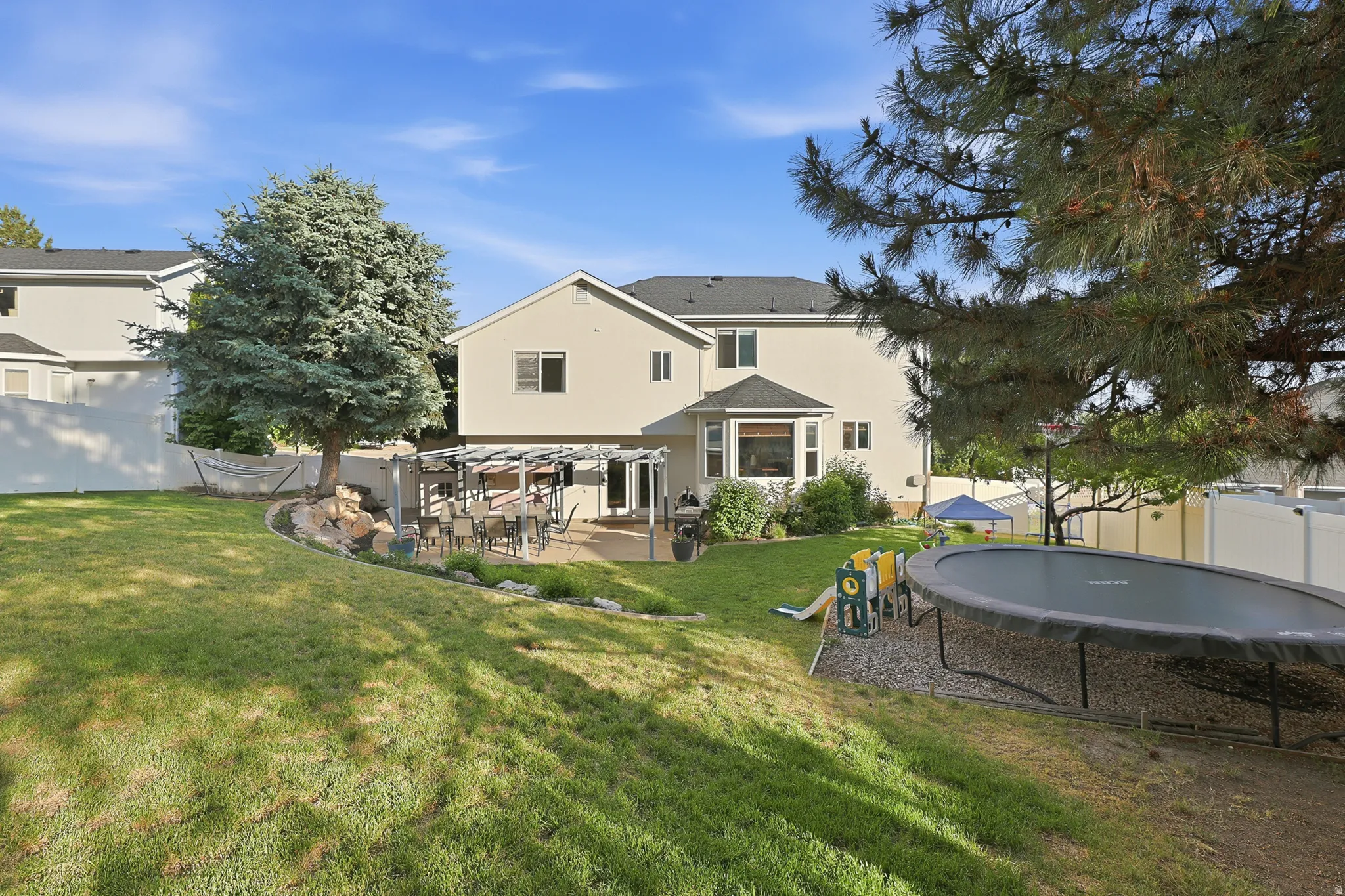 Expansive backyard with a sloped lawn and mature trees