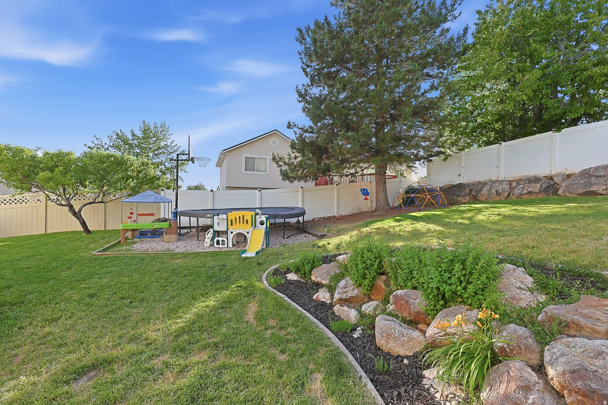 Expansive backyard with a manicured lawn and mature trees