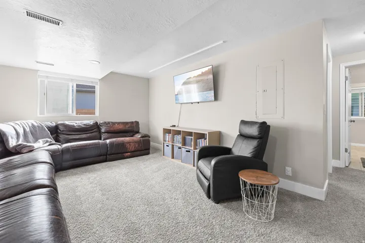 Spacious room featuring light-colored walls, recessed lighting, and soft grey carpeting throughout