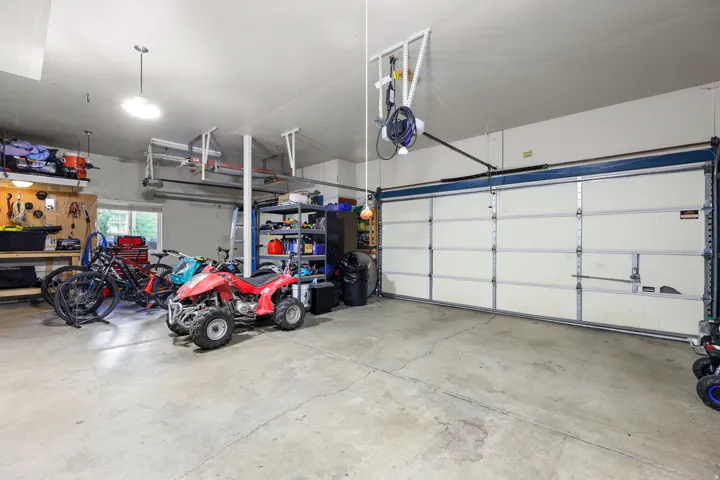 Spacious garage featuring a concrete floor, overhead lighting, and a wide garage door