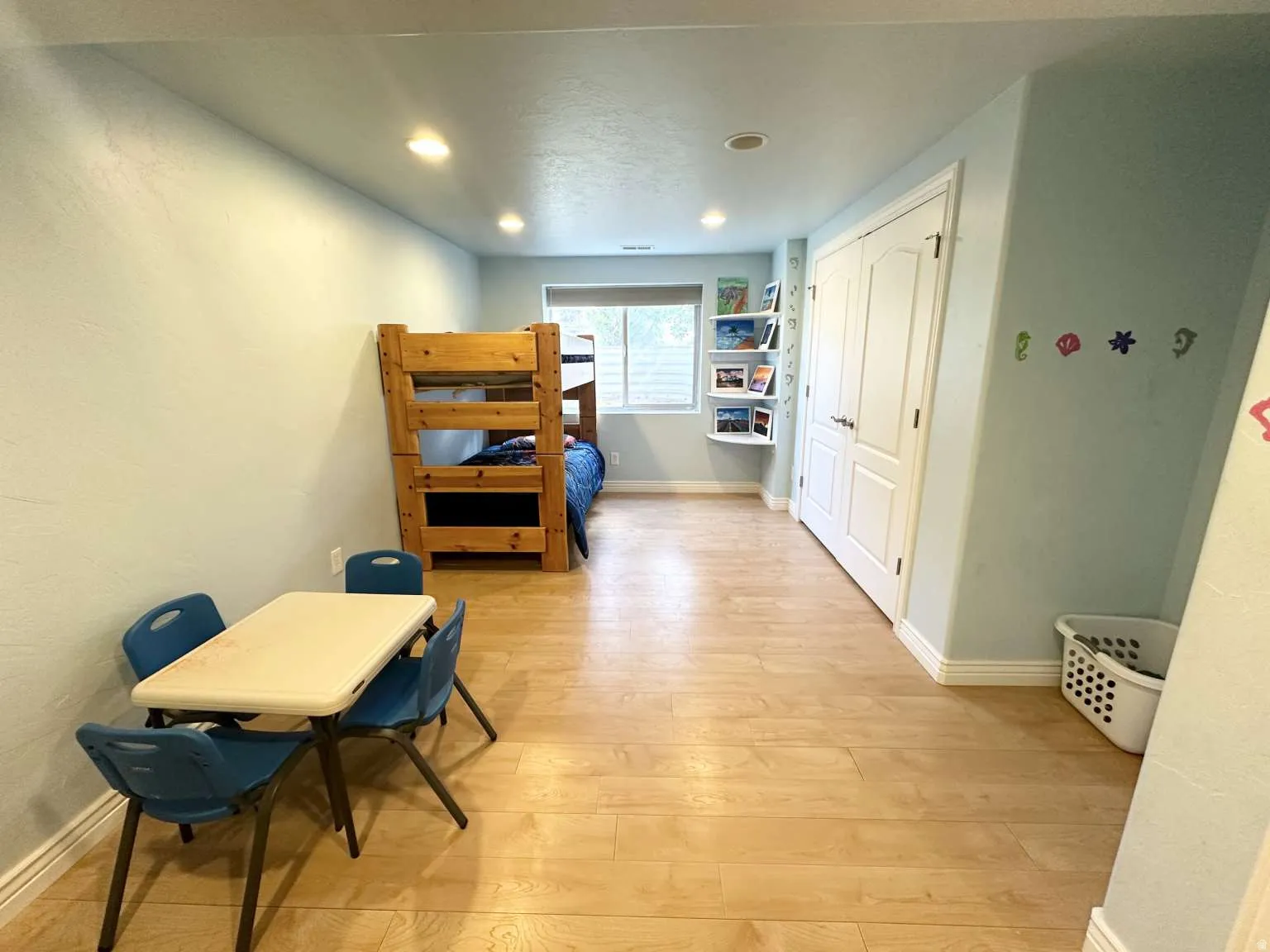 Spacious room featuring light wood-finish flooring, recessed lighting, and a window with blinds