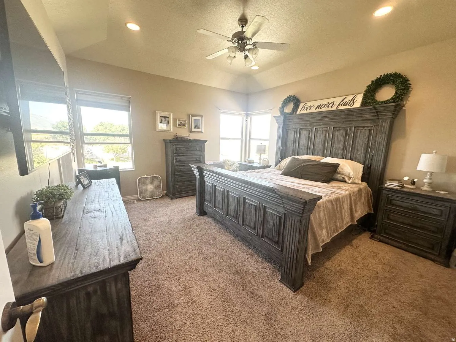 Carpeted bedroom with a vaulted ceiling and recessed lighting