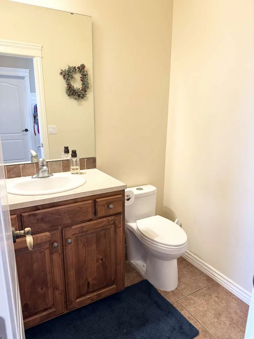 Bathroom vanity with a white countertop and integrated sink, set against neutral-toned walls