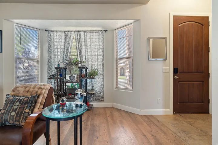Bay window with natural light, wood-finish flooring, and a paneled wooden door