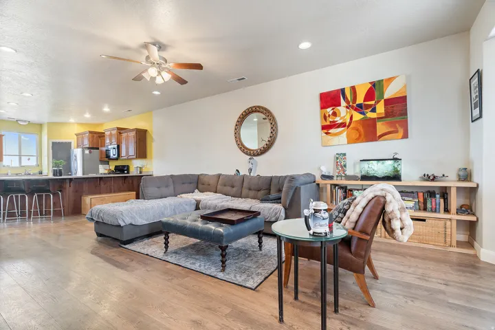 Open-concept living space featuring wood-finish flooring, recessed lighting, and a ceiling fan