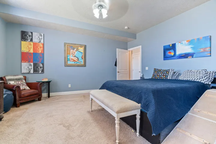 Carpeted room featuring light blue walls, white trim, and a ceiling fan with integrated lighting