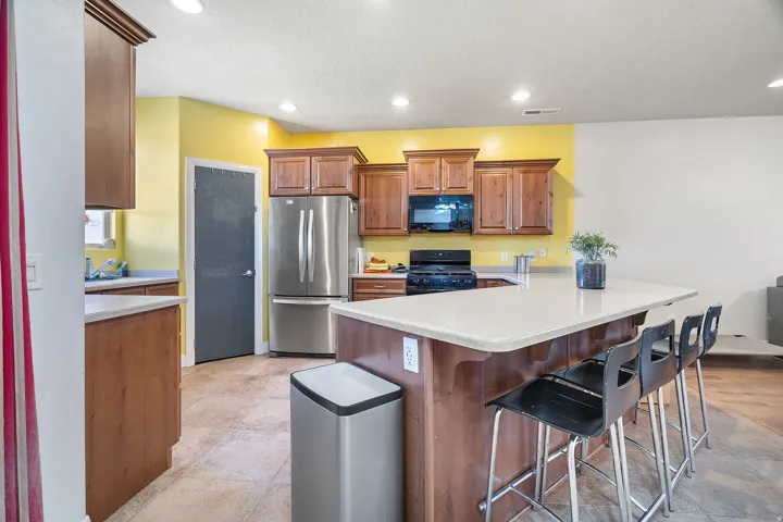 Kitchen featuring wood cabinetry, stone-look countertops, and recessed lighting