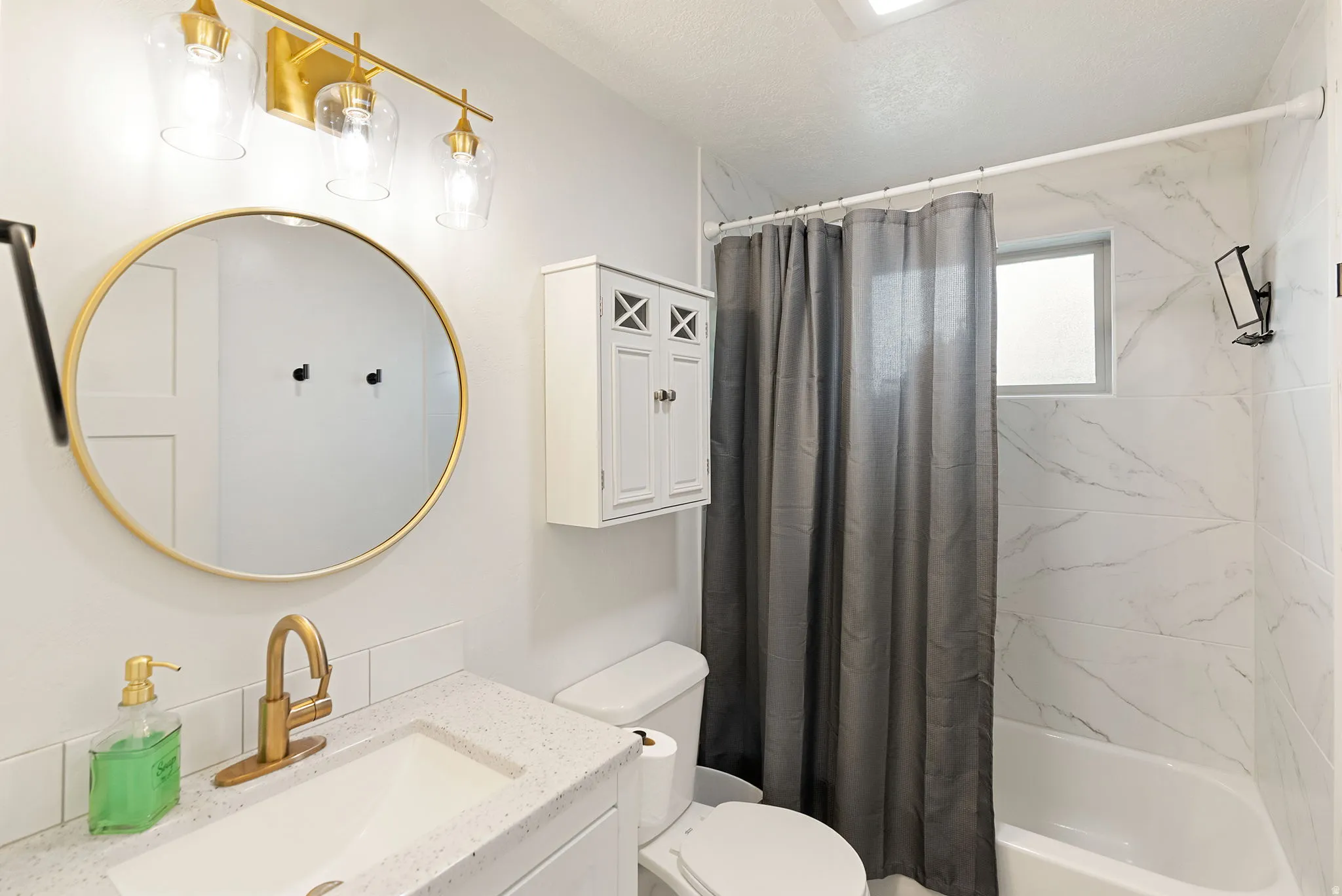 Bathroom featuring a modern vanity with a white countertop and gold-finish faucet