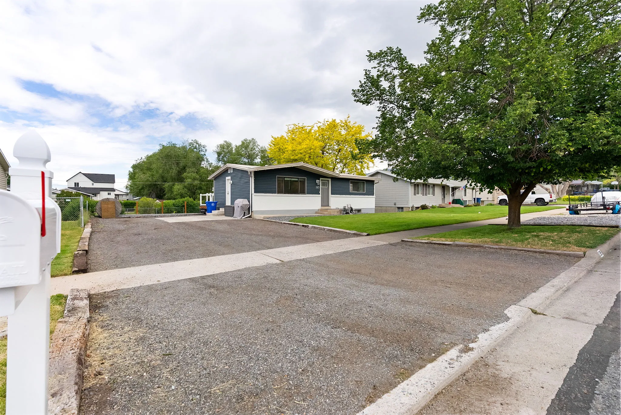 Gravel driveway with concrete borders providing ample parking