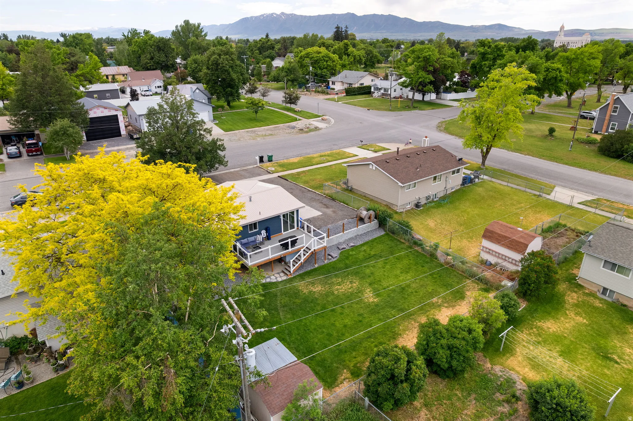 Aerial perspective featuring a property with an expansive green lawn and a multi-level deck