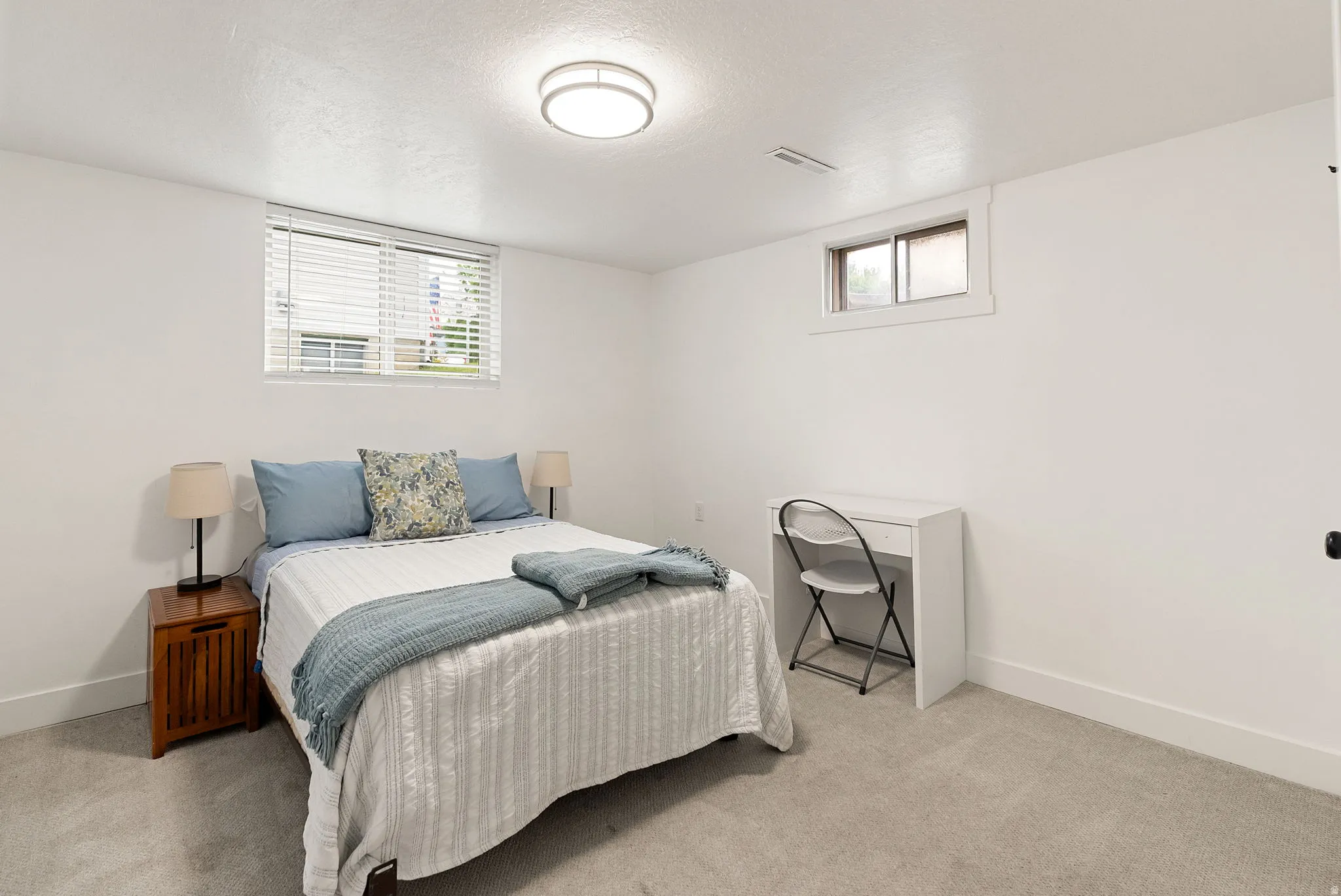 Carpeted room featuring white walls, baseboards, and window trim