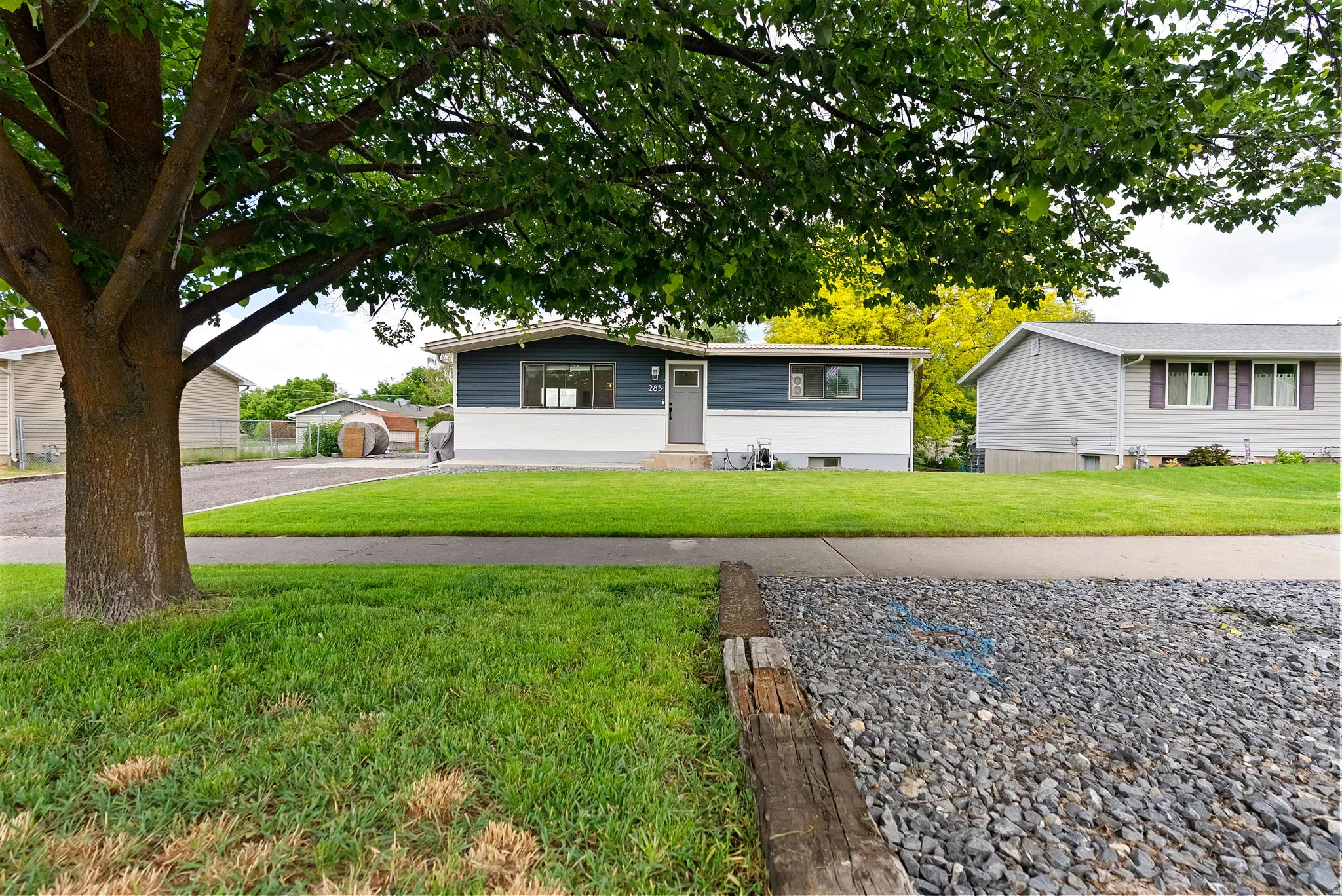Single-story residence featuring a gray and white exterior with a contrasting gray front door