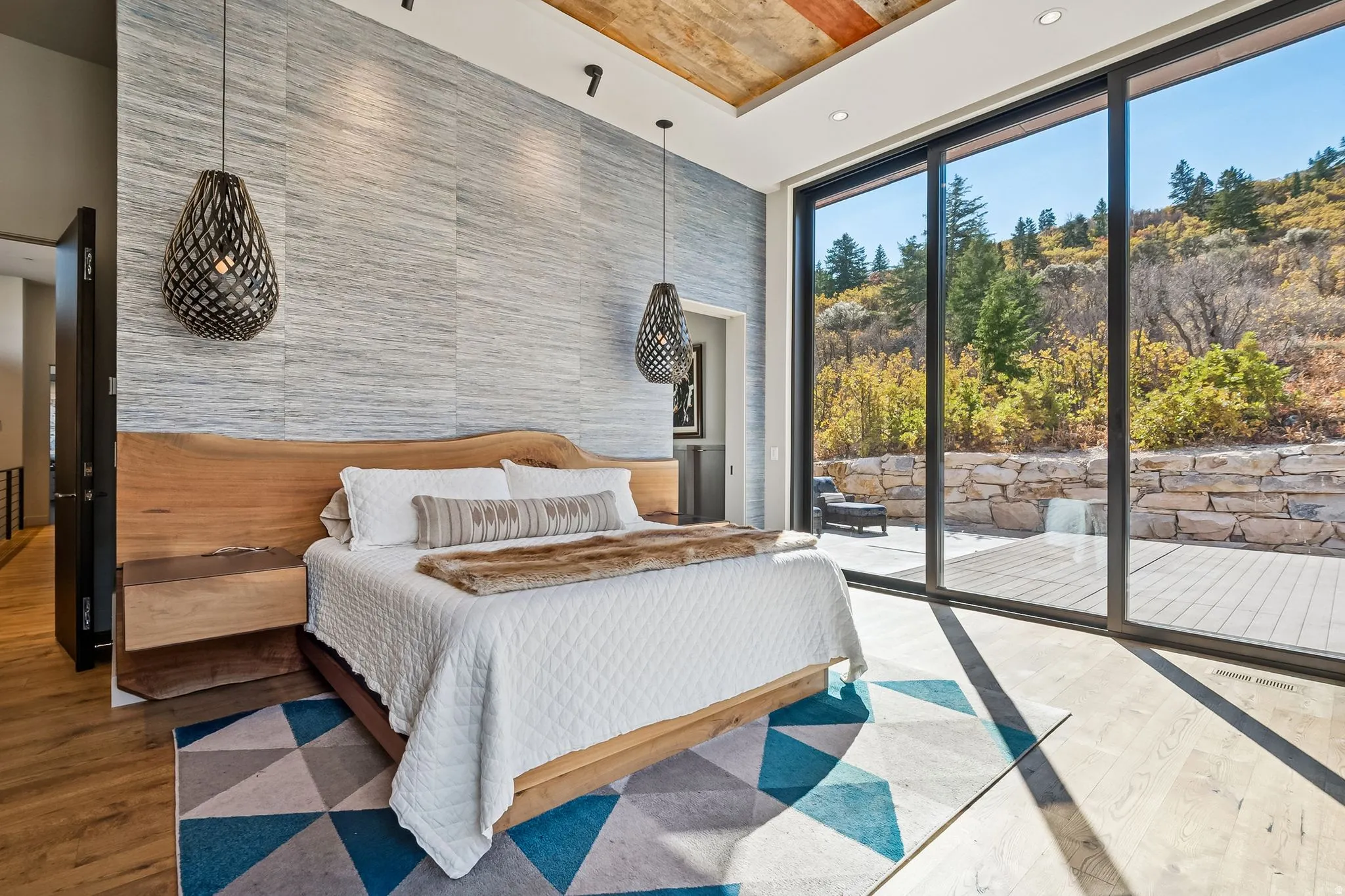 Bedroom featuring expansive windows, wood finished floors, and access to exterior