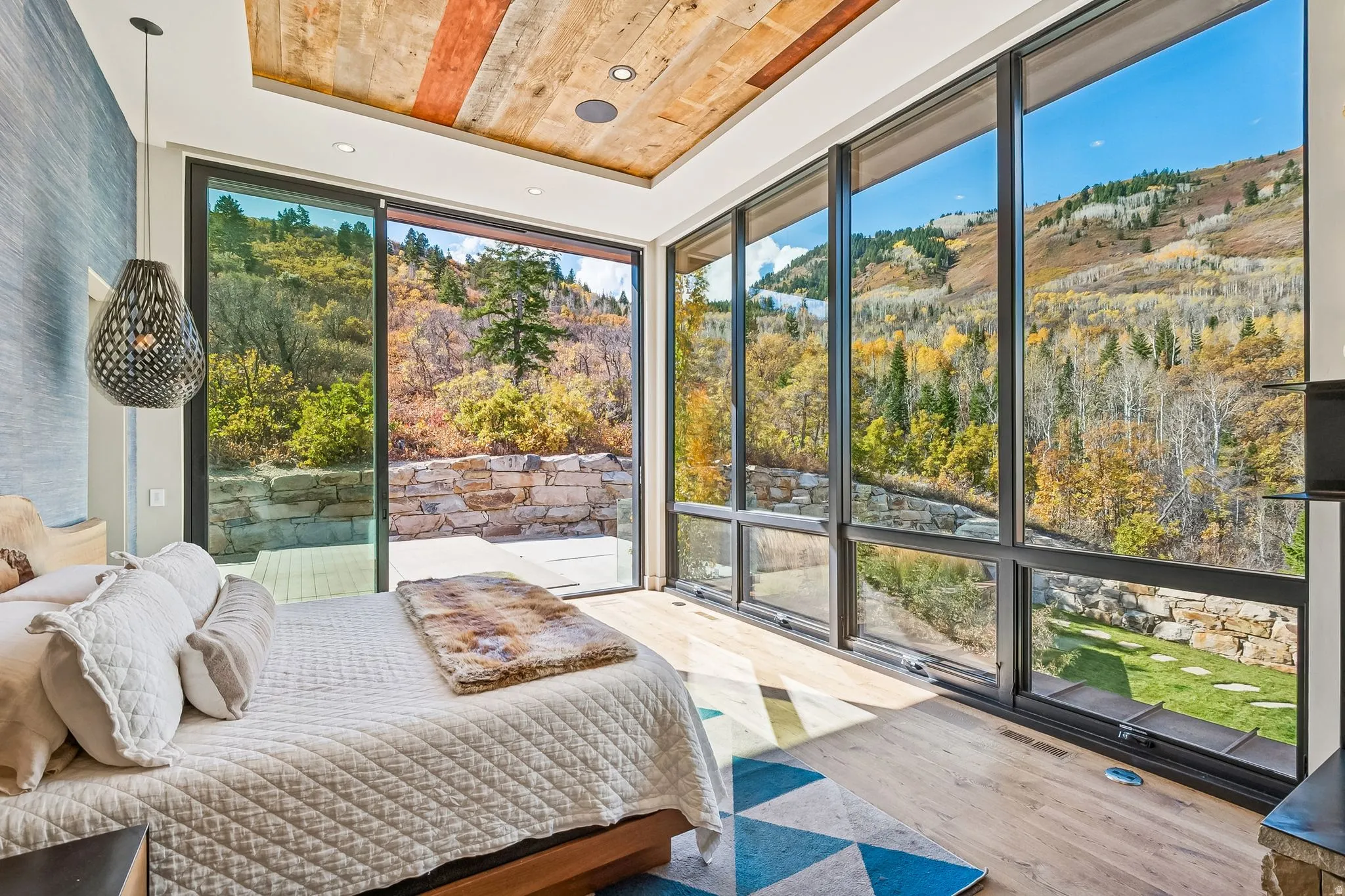 Bedroom featuring floor to ceiling windows, a wood tray ceiling, wood finished floors, and recessed lighting