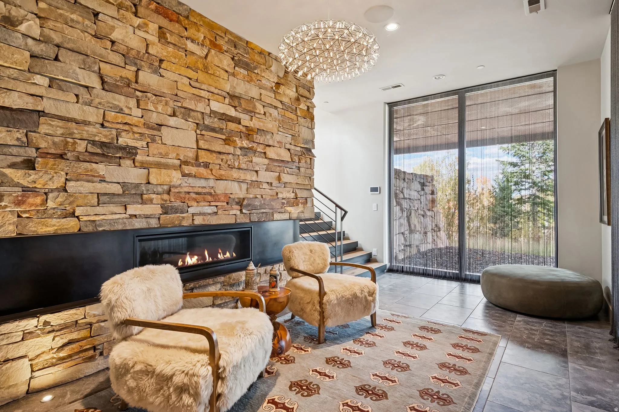 Sitting room with expansive windows, a fireplace, and recessed lighting