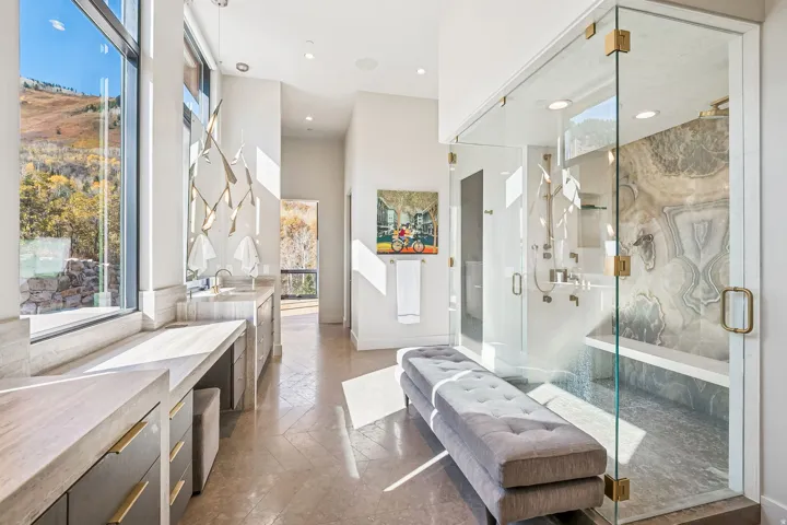 Bathroom with stone tile flooring, vanity, a marble finish shower, recessed lighting, and a high ceiling