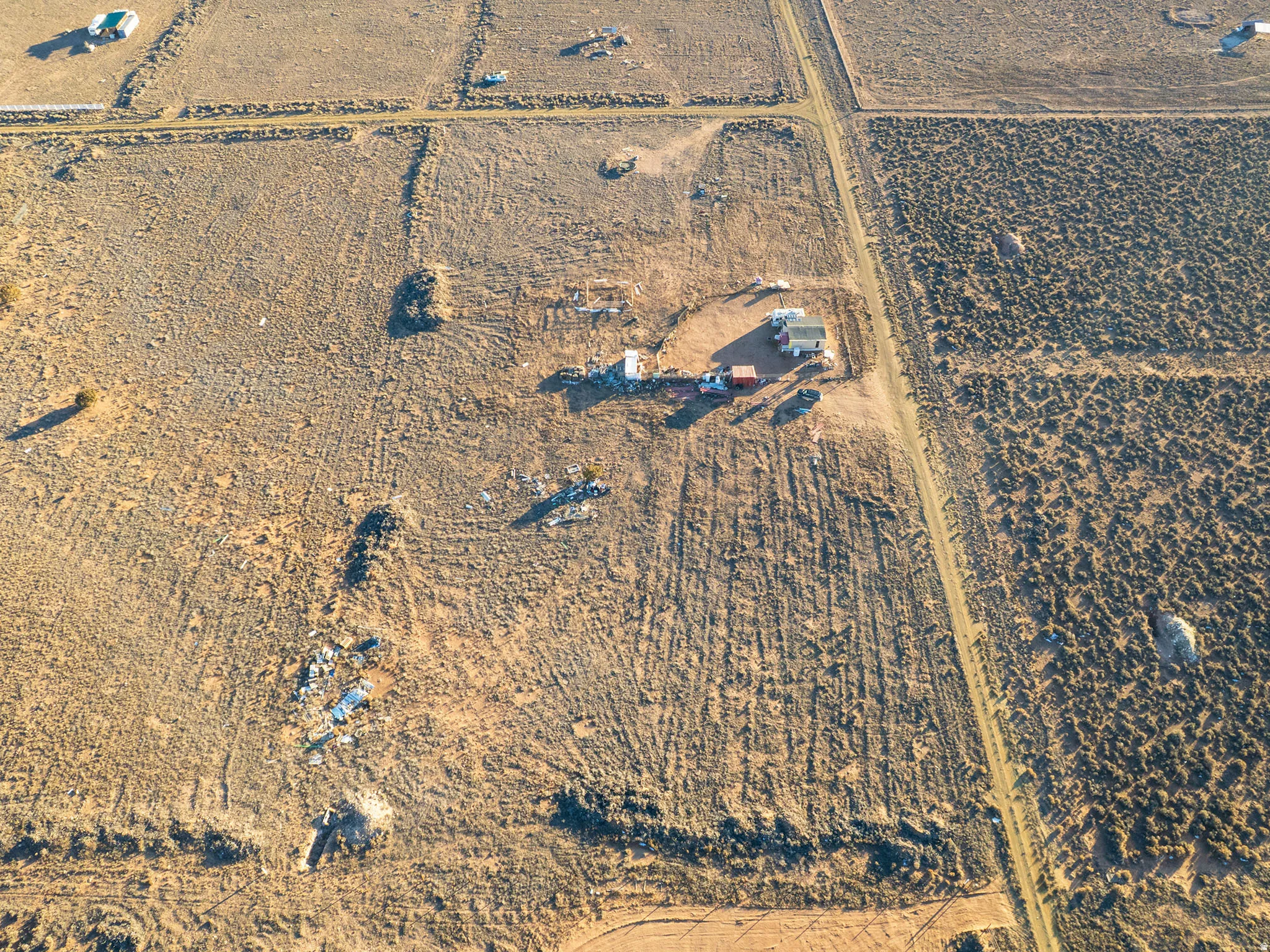 Expansive undeveloped land featuring a detached structure and several outbuildings