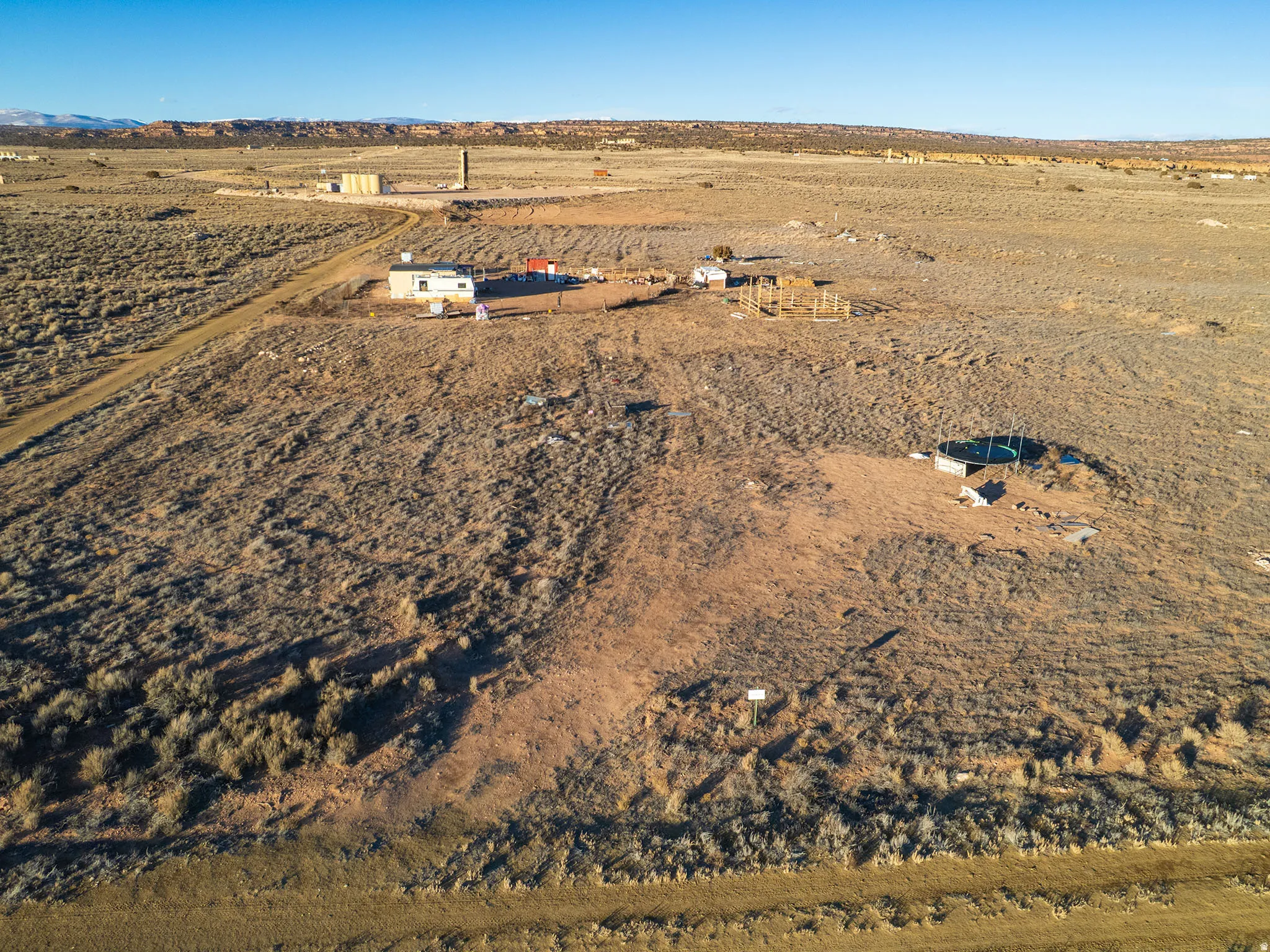 Expansive undeveloped land featuring a dirt road and scattered brush