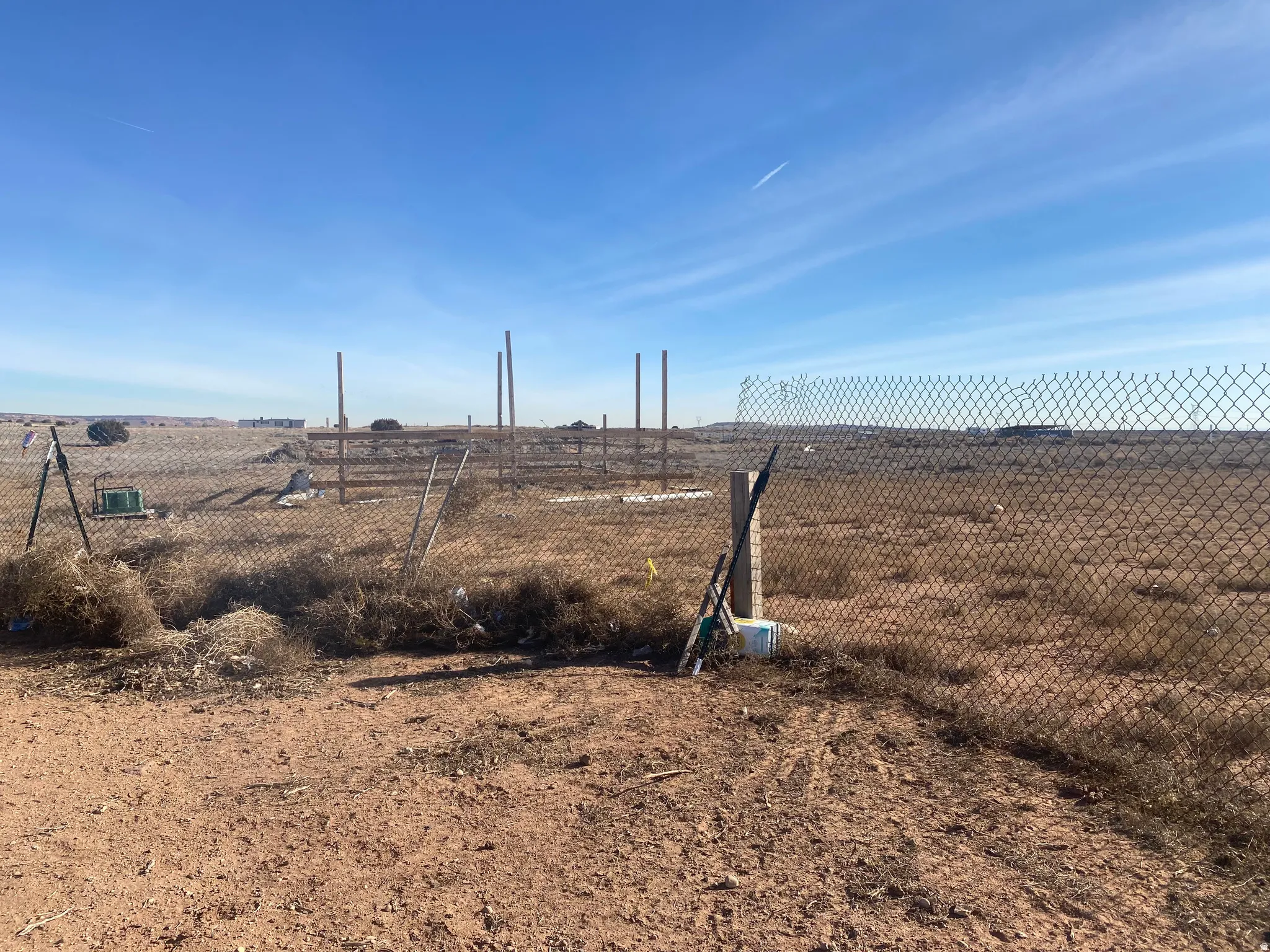 Expansive undeveloped lot featuring a chain-link fence and open terrain