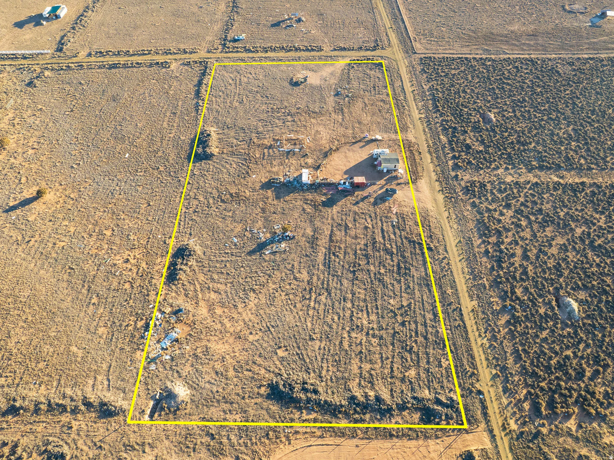 Expansive land parcel with clearly defined boundaries, featuring a main structure and accessory building