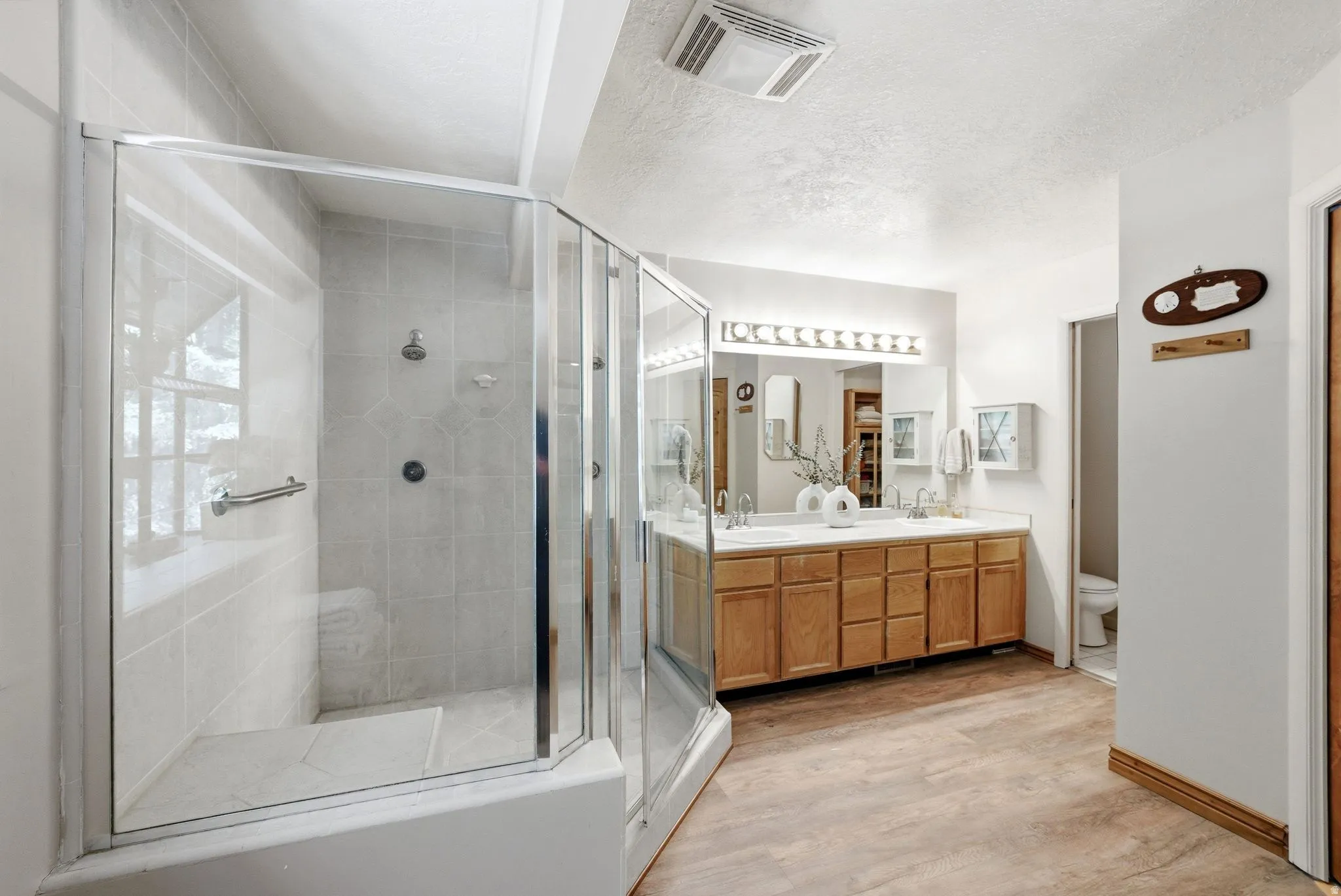 Glass-enclosed shower with tiled walls and a built-in bench